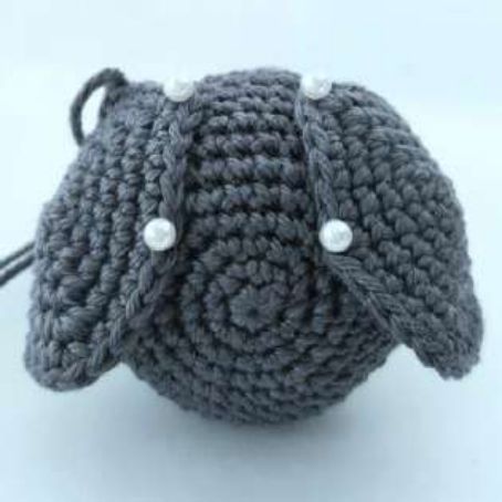 Top view of a crochet bat head with both ear tips pinned flat against it
