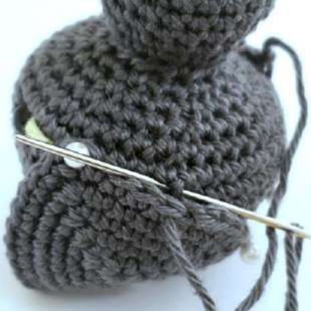 Tapestry needle sewing the edge of a crochet bat ear to the head