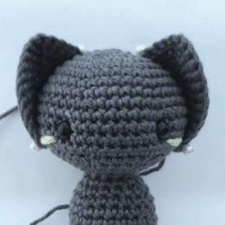 Front view of a crochet bat with both ears pinned in place