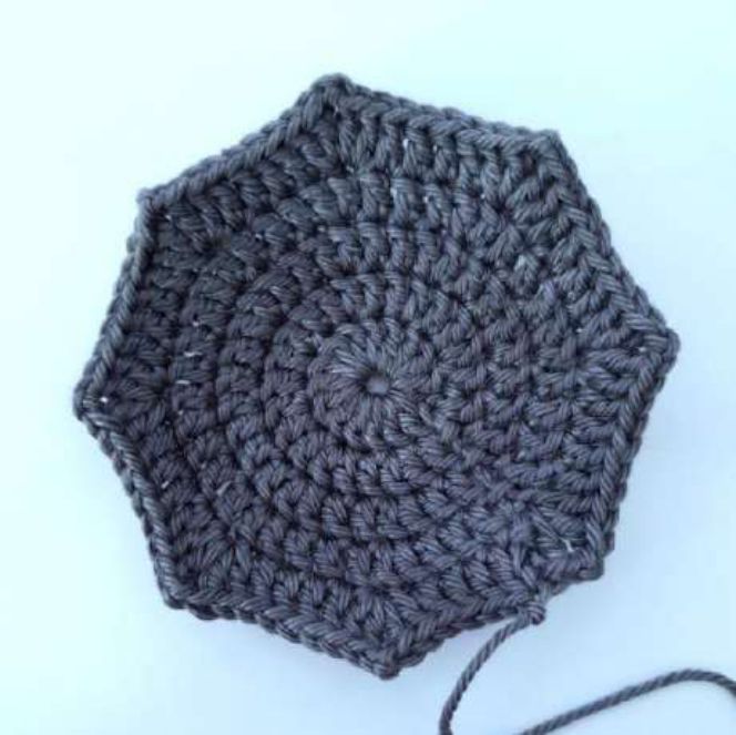 Flat crochet circle in double crochet with seven pointed edges, before folding into a bat wing
