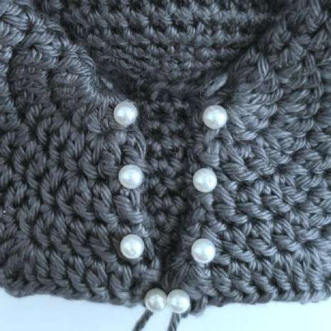Back of a crochet bat body with both wings pinned in a narrow V shape
