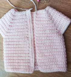 Pink crochet cardigan laid open with both front bands finished