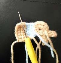 Back of the crochet bunny with the hook working a cluster