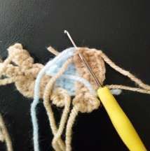 Back of the crochet bunny with the hook adding the white tail