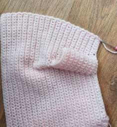 Pink crochet front edge folded to show the start of the button band