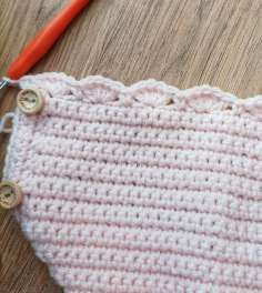 Row of crochet shells along the bottom of the pink cardigan