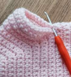 Sleeve rows worked around the armhole of the pink crochet cardigan