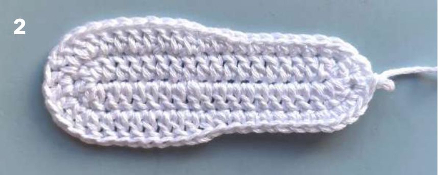 White crochet sole after round 2, rounded at both ends