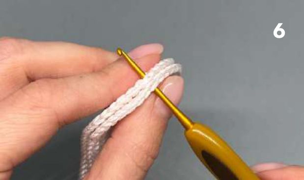 Crochet hook working slip stitches through the edges of both soles