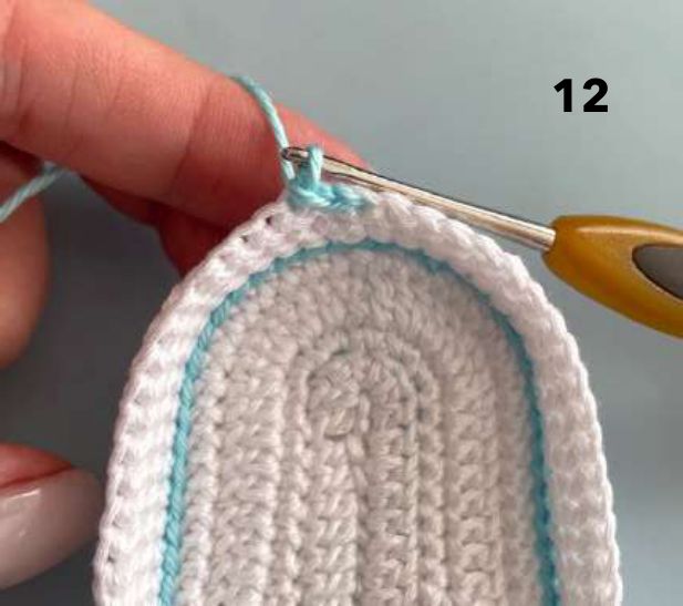 Aqua slip stitches worked along the top edge of the white crochet sides, seen from the inside
