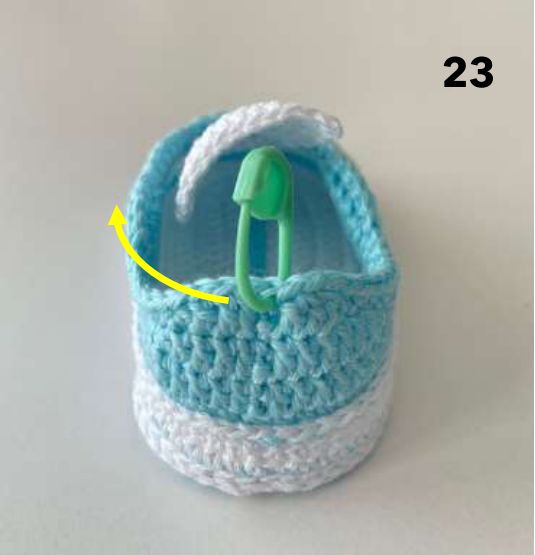 Heel of a crochet sneaker with a marker at the middle and an arrow pointing to the left