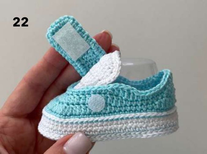 Underside of the crochet strap with white hook and loop tape, and a tape dot on the side of the shoe