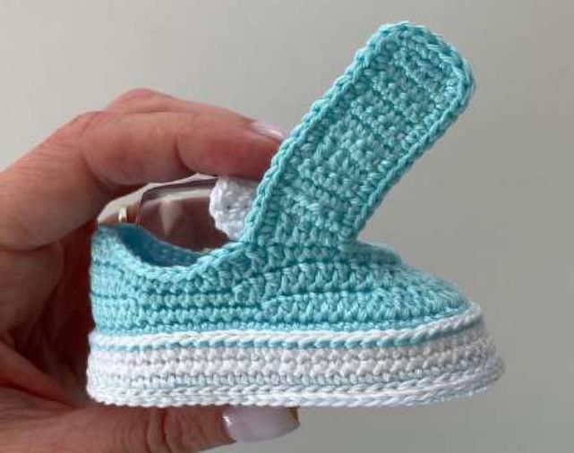 Aqua crochet strap with a neat edge, standing up from the side of the sneaker