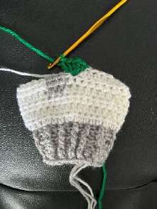 Five green double crochet stitches worked into one stitch