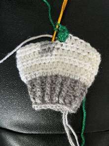 Row of green bobbles on the white crochet leg