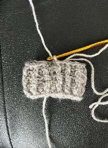 Gray ribbed crochet cuff with two loops of the last stitch on the hook