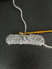 Gray crochet band with the right side facing, ready to work along the bottom edge