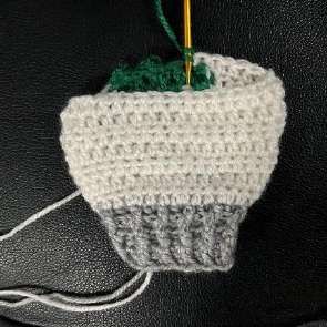 White crochet leg with the green tree growing above the silver trunk