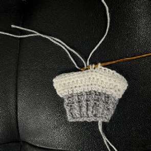 White crochet leg with the first silver stitches of the tree trunk