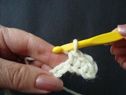Hook pulling a long loop up to cross a crochet cable