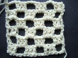 Cream crochet checkerboard square with an open grid
