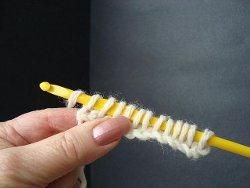 Long row of loops held on a yellow crochet hook in Tunisian crochet