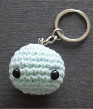 Round mint green crochet jellyfish head with black safety eyes and a keychain ring on top