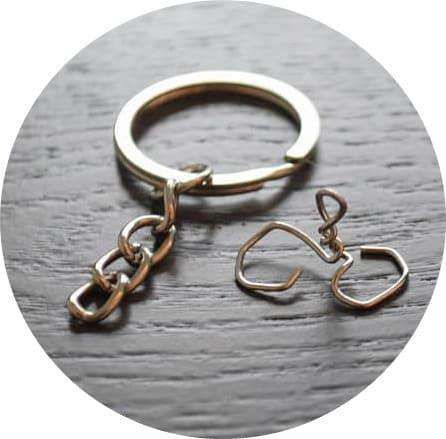 A silver keychain ring with a short chain and a bent paper clip