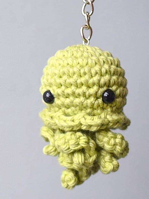 Lime green crochet jellyfish keychain with black eyes and curly tentacles