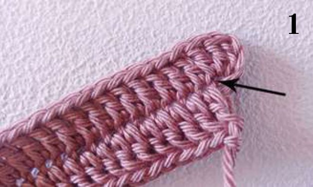 Pink crochet sample with an arrow at the stitches worked into the last chain