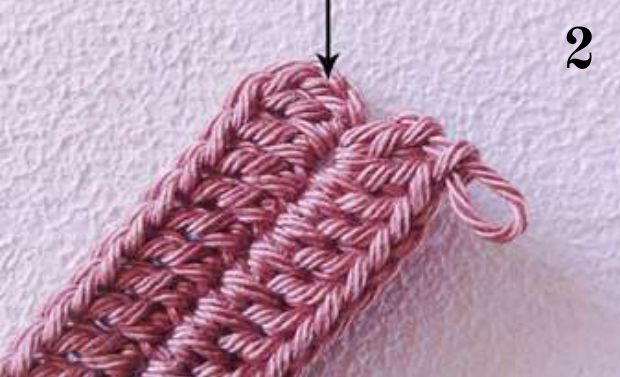 Pink crochet sample with an arrow at the slip stitch joining round 1
