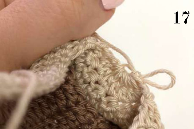 Hand holding the crochet shoe as the toe closes
