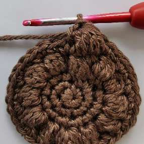 Brown crochet circle with a full round of bobble stitches
