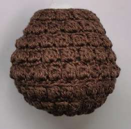 Brown crochet pine cone body covered in rows of bobble stitches