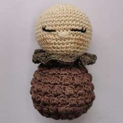 Crochet doll with a green ruffled collar around the neck