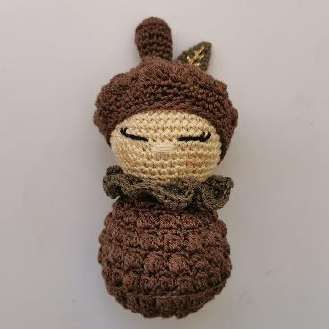 Finished crochet pine cone baby doll with its cap, leaf and collar