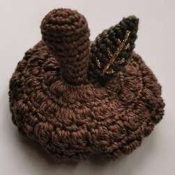 Brown crochet cap with the stalk and leaf sewn on top