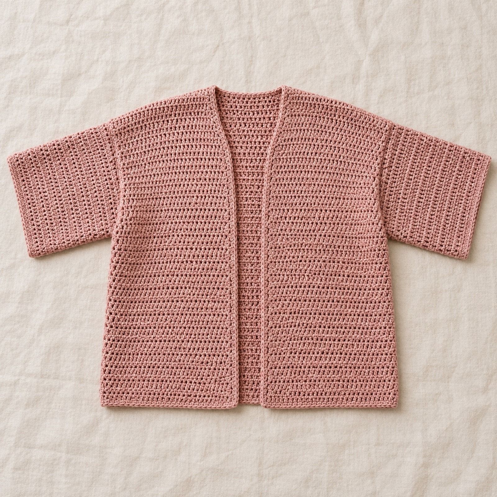 Dusty rose crochet cardigan with an open front and wide three quarter sleeves.